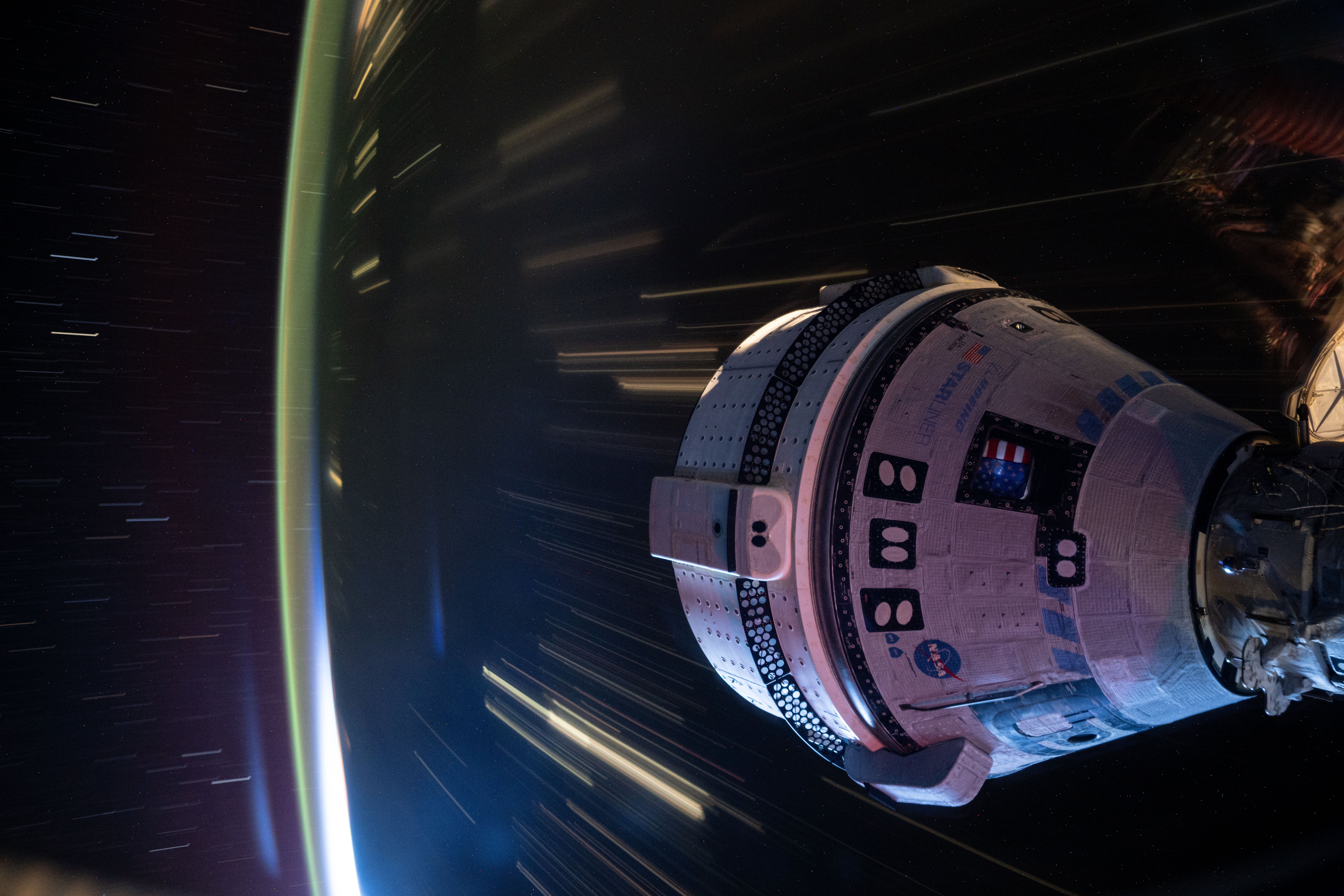 The Boeing Starliner spacecraft that launched NASA astronauts Butch Wilmore and Suni Williams from the Manned Test Program to the International Space Station is seen docked to the front port of the Harmony module. This long-term photograph was taken at night from the orbiter as it ascended 415 kilometers above western China.