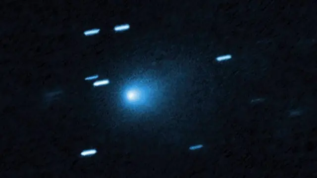 Image of the interstellar comet 3I/ATLAS, showing a bright nucleus with a trail against a dark blue background
